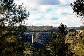 Photo by Joel Durkee A view of a bridge through some trees